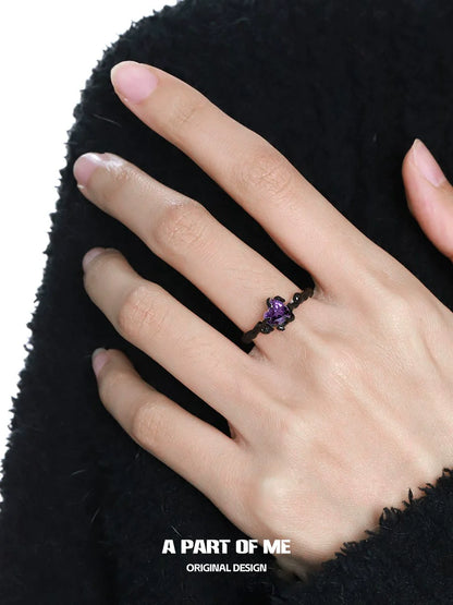 A PART OF ME little demon goth ring featuring a dark design with purple accents worn on a hand