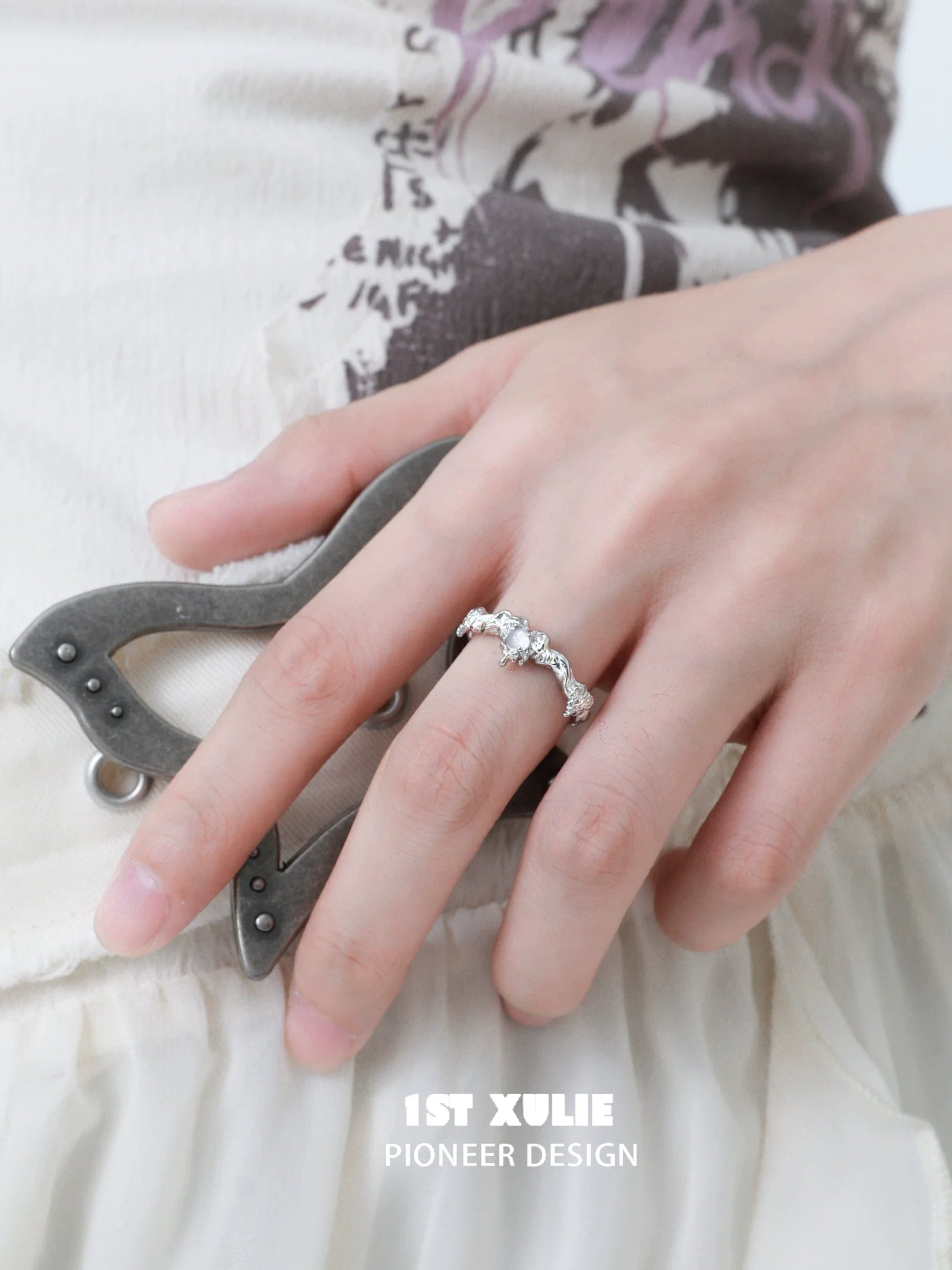 Elegant love agate silver ring displayed on a hand near decorative gray accessory