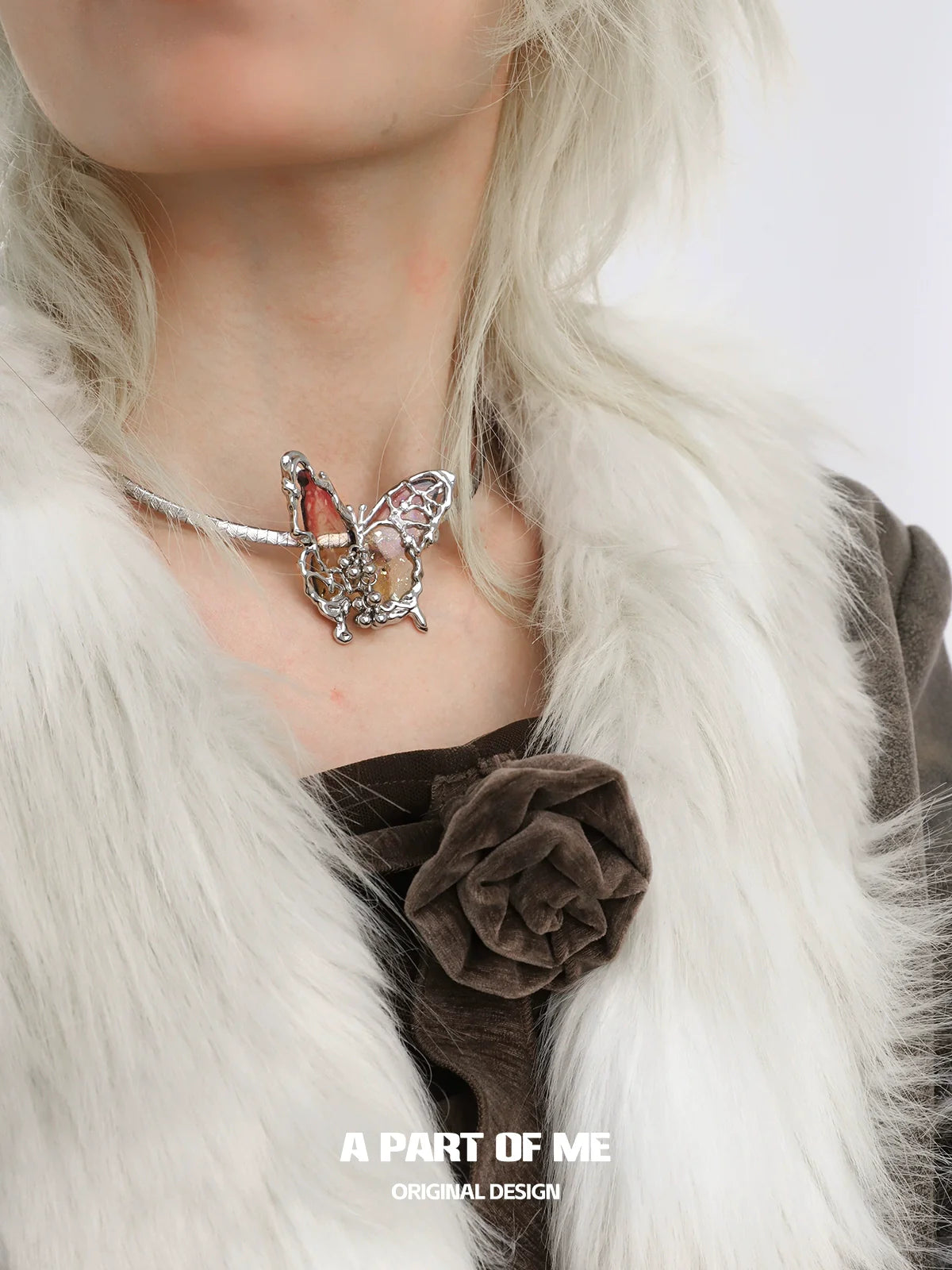 A PART OF ME mechanical butterfly necklace with intricate detailing and silver accents worn on a model