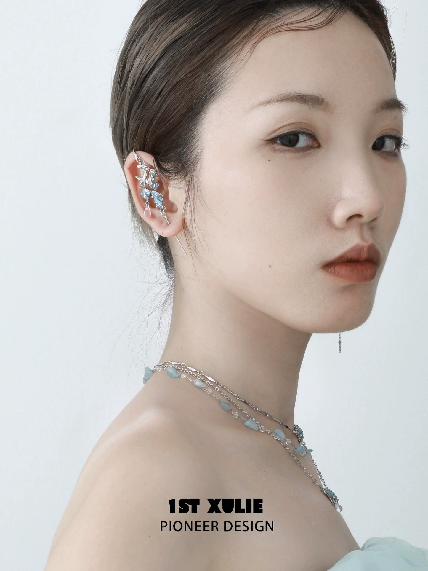 Elegant mermaid tail ear piercing jewelry displayed on a model's ear with a soft, stylish look