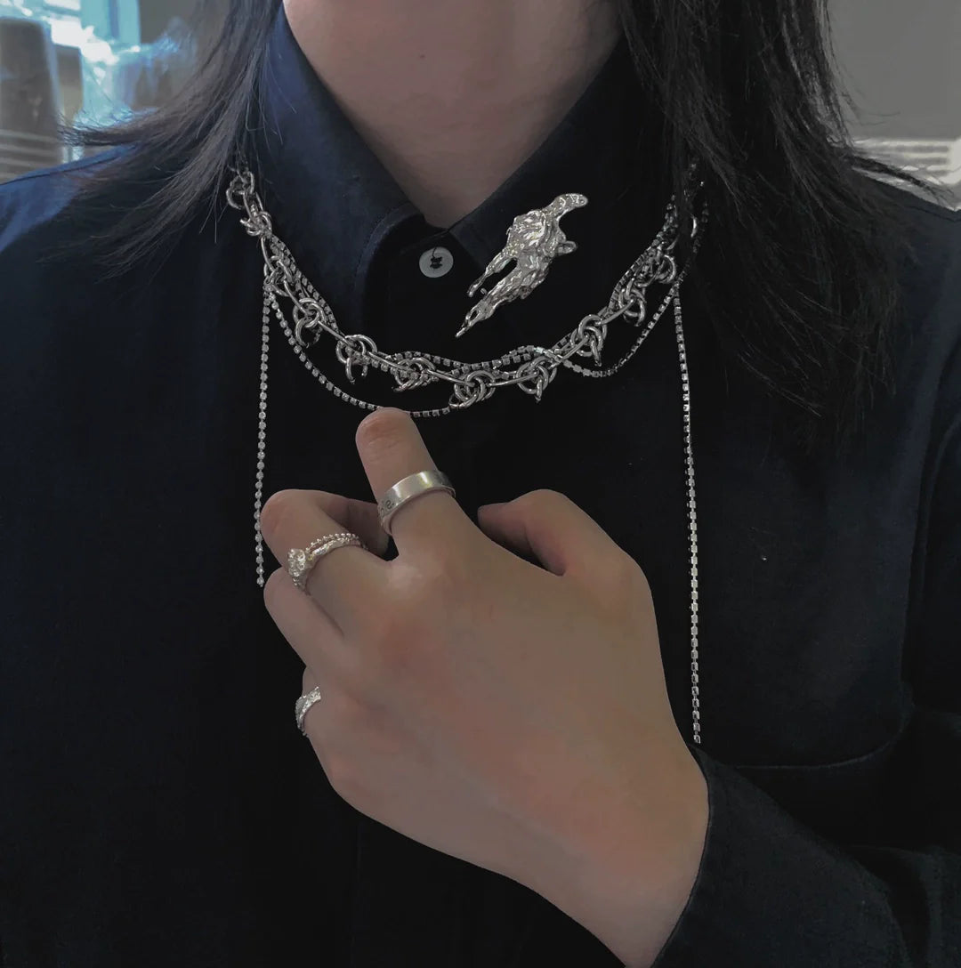 Stylish model wearing a meteorite silver brooch on a layered silver chain outfit