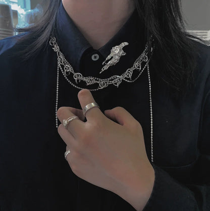 Stylish model wearing a meteorite silver brooch on a layered silver chain outfit