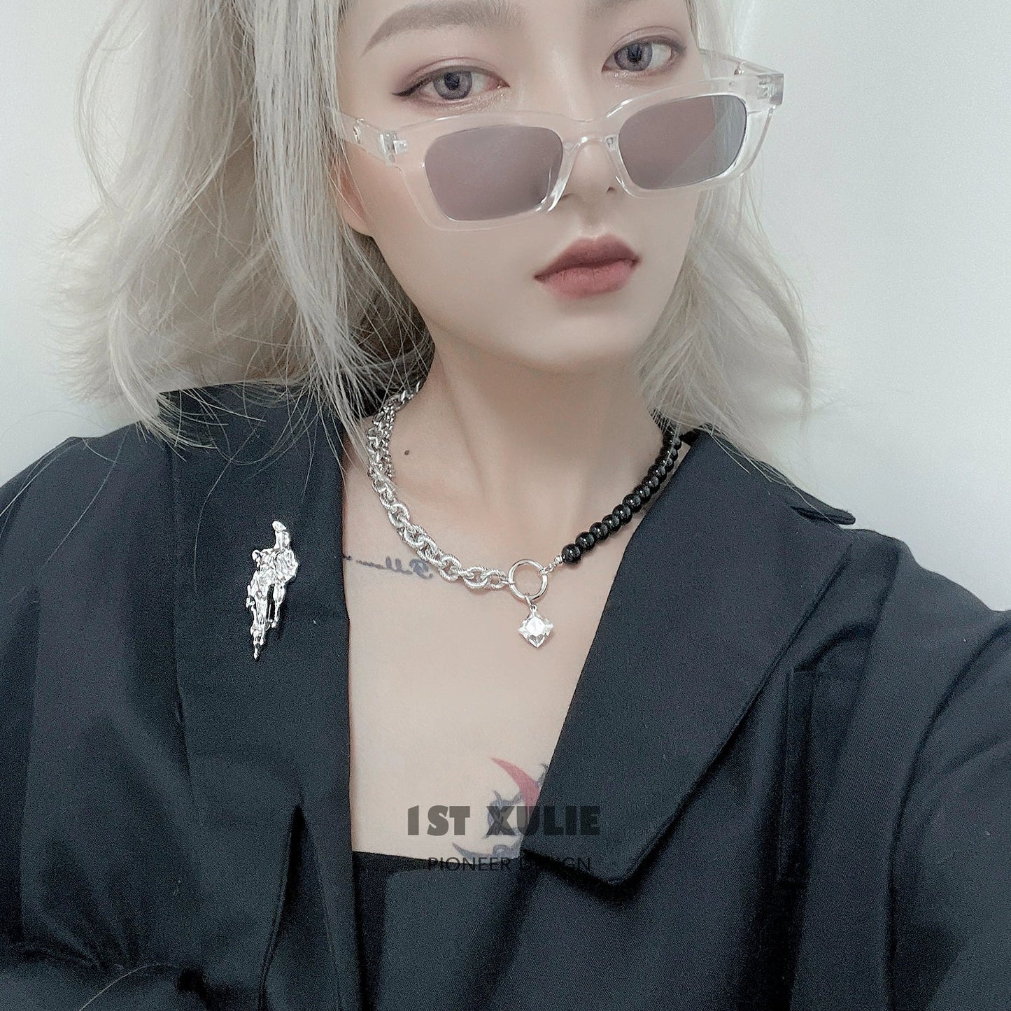Stylish model wearing a meteorite silver brooch on a black outfit with sunglasses