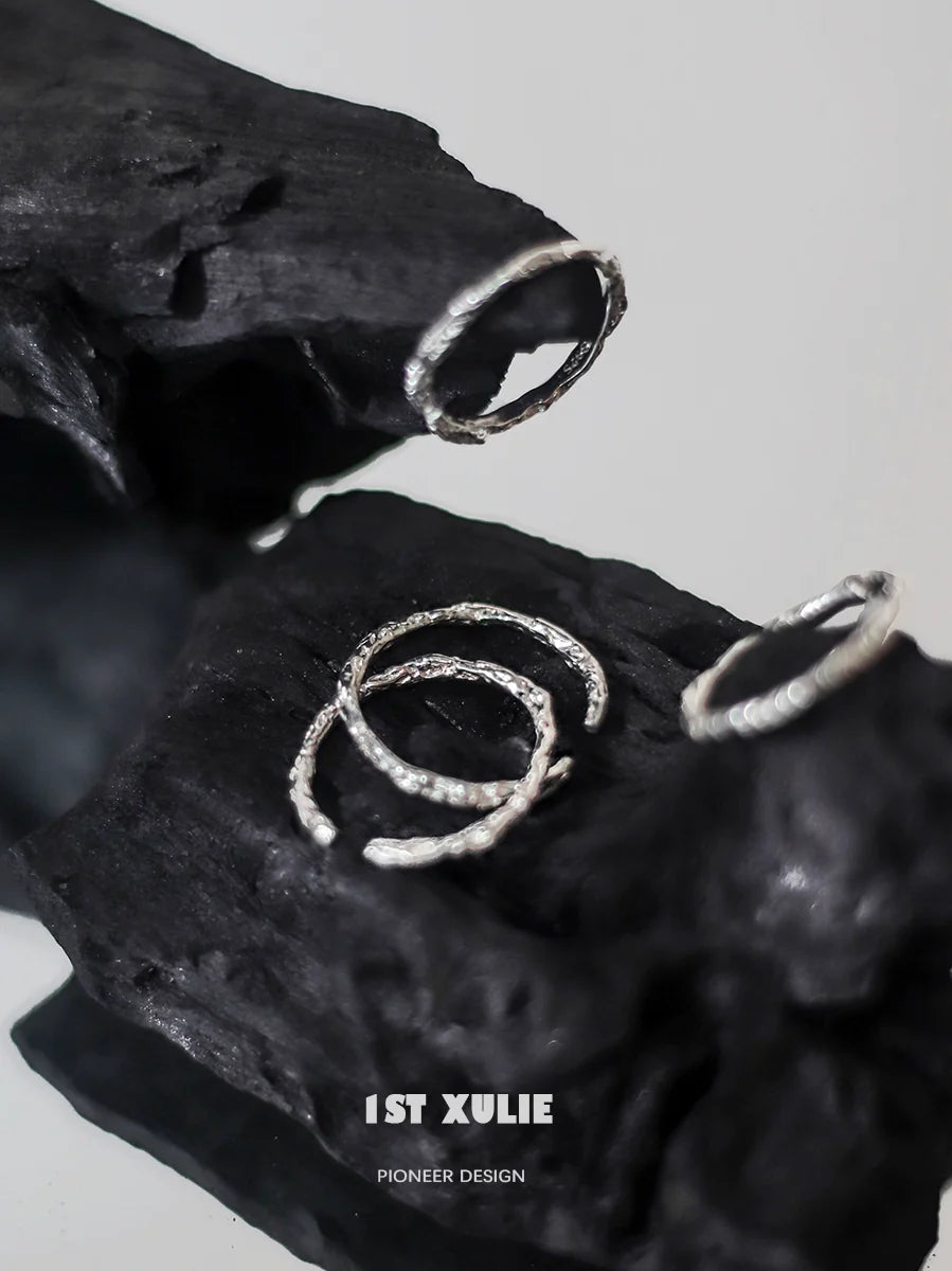 Minimalist silver ring set displayed on textured black surface for modern jewelry lovers