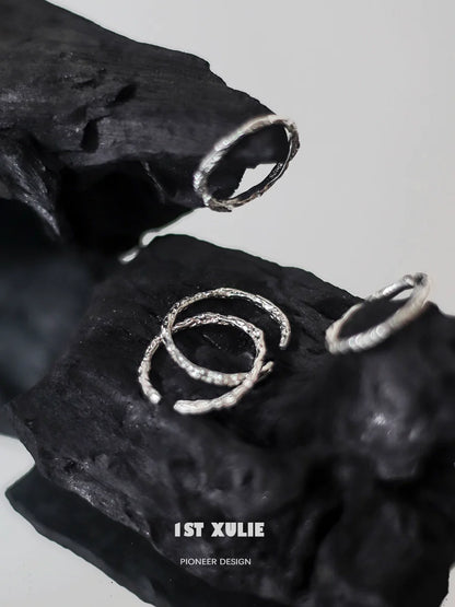 Minimalist silver ring set displayed on textured black surface for modern jewelry lovers