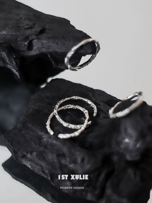 Minimalist silver ring set displayed on textured black surface for modern jewelry lovers