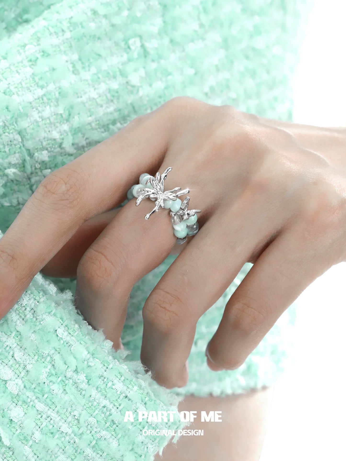 Mint butterfly beaded ring on a hand, showcasing delicate design and elegant colors