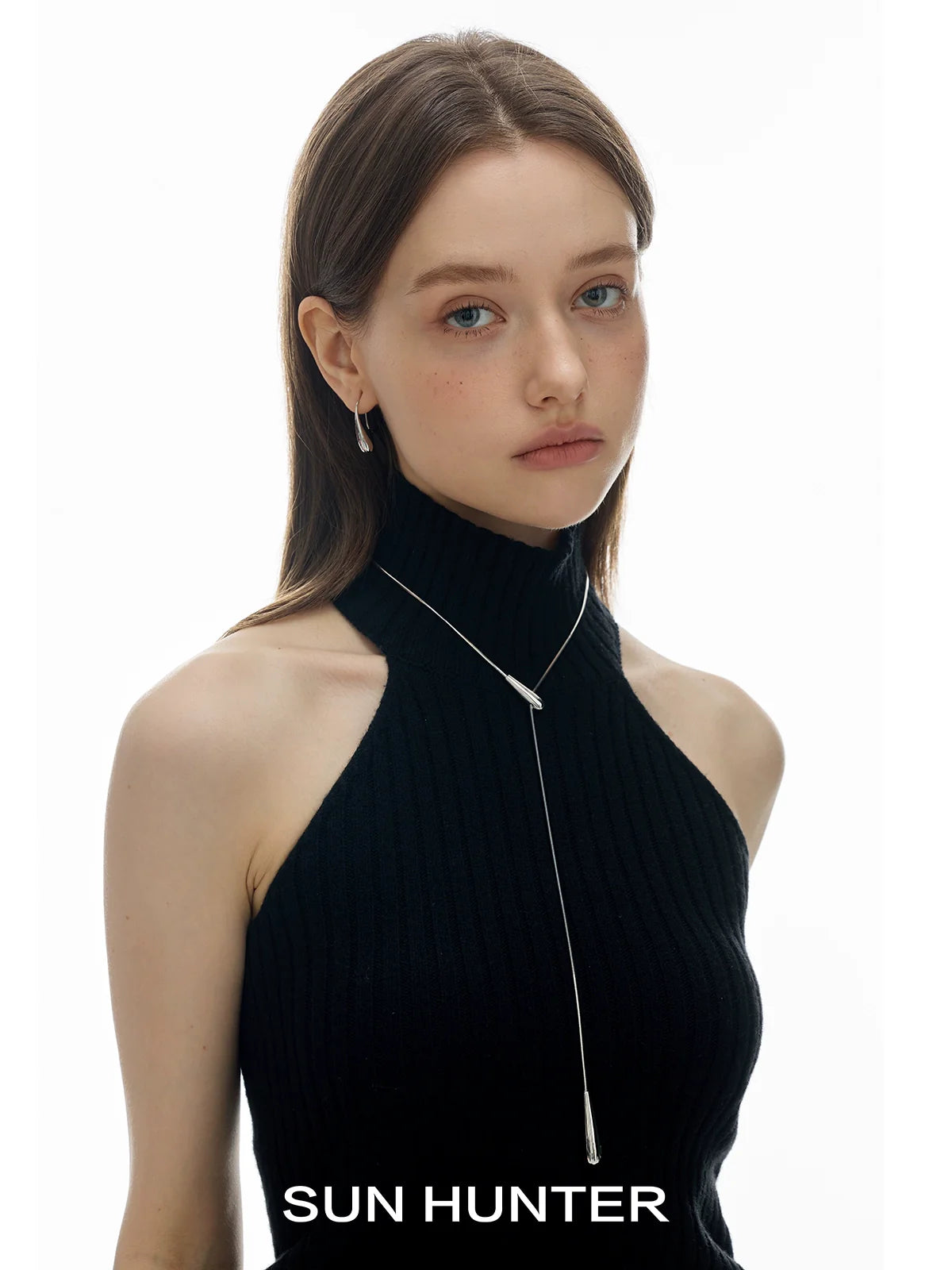Elegant model wearing a SUN HUNTER molten drop necklace, showcasing its sleek and modern design