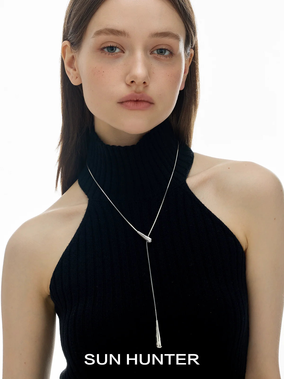 SUN HUNTER molten drop necklace elegantly worn by model with a stylish black top