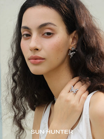 Elegant model wearing SUN HUNTER mystic butterfly ring and matching jewelry with a serene expression