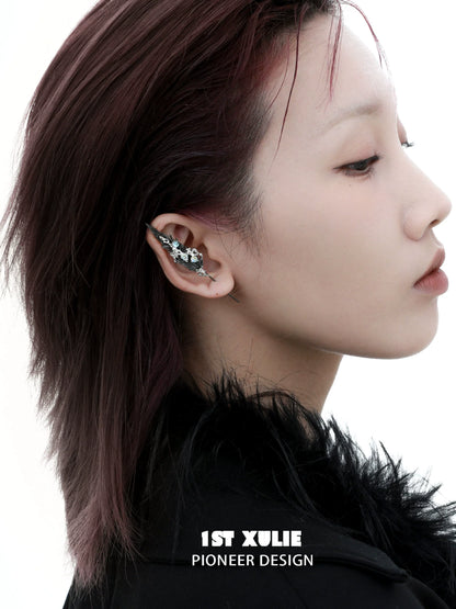 Unique mystic feather piercing earring designed by 1ST XULIE, showcased on a model's ear
