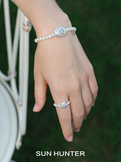 Stylish ocean memory pearl bracelet on a hand with a pearl ring for elegant jewelry lovers
