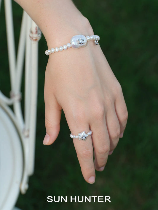 Stylish ocean memory pearl bracelet on a hand with a pearl ring for elegant jewelry lovers