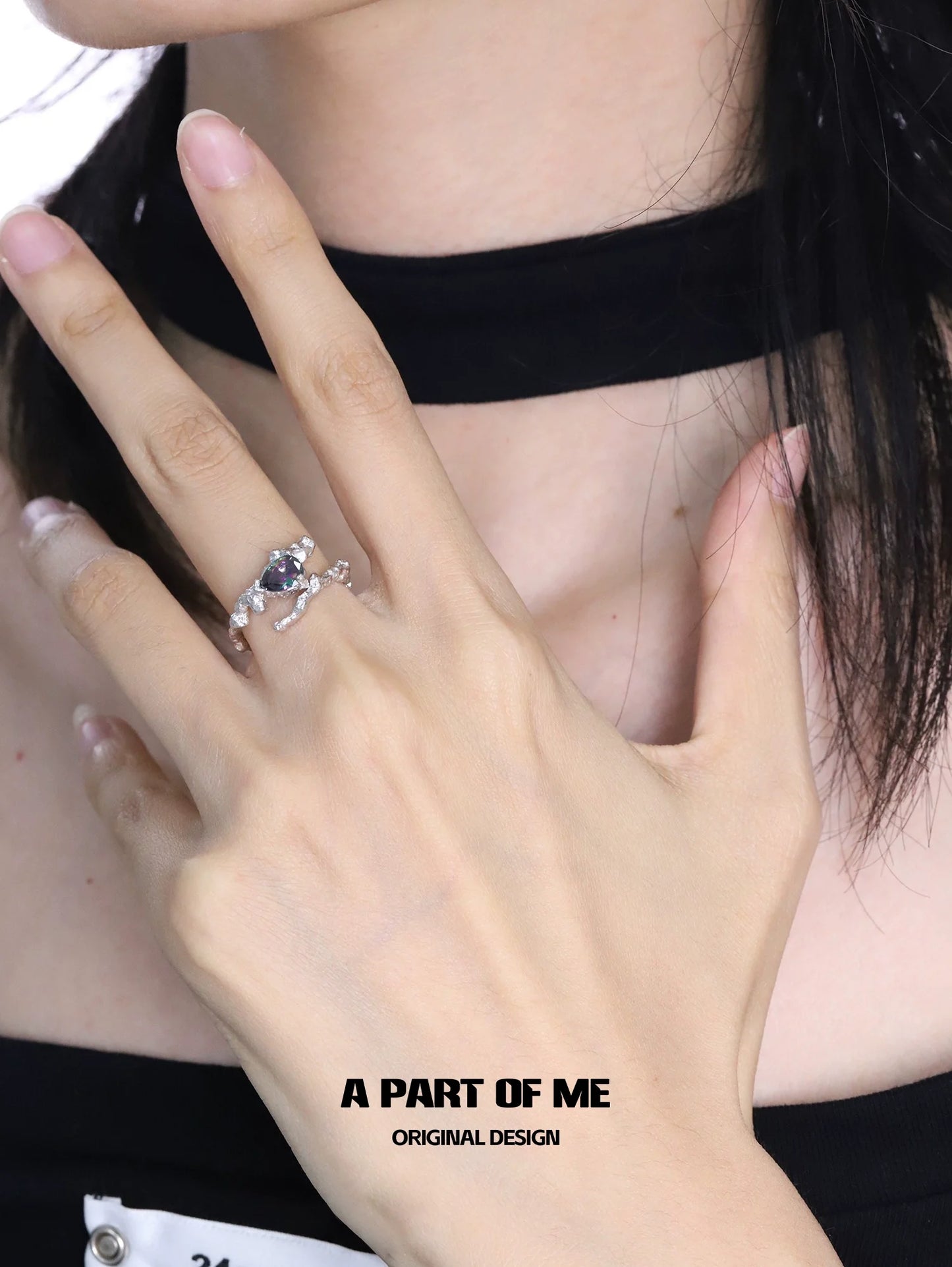 Close-up of a hand wearing an amethyst silver vine ring featuring intricate design and sparkling details