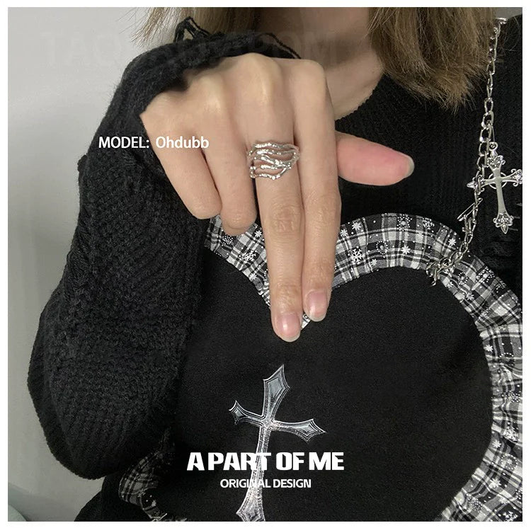 Stylish bone minimalist ring on a hand wearing a black sweater with a heart design