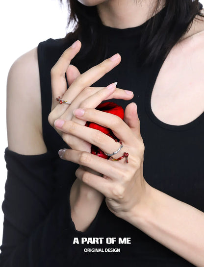 Heartburst rose silver ring showcased on elegantly styled hands holding a red gem