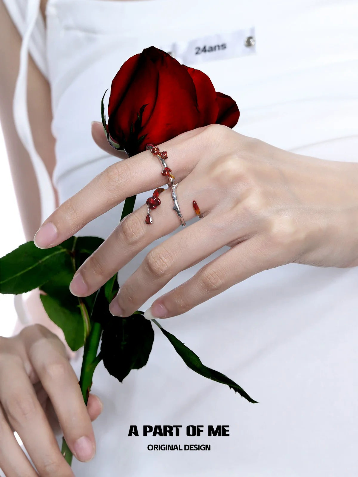 A PART OF ME heartburst rose silver ring displayed on a hand holding a red rose