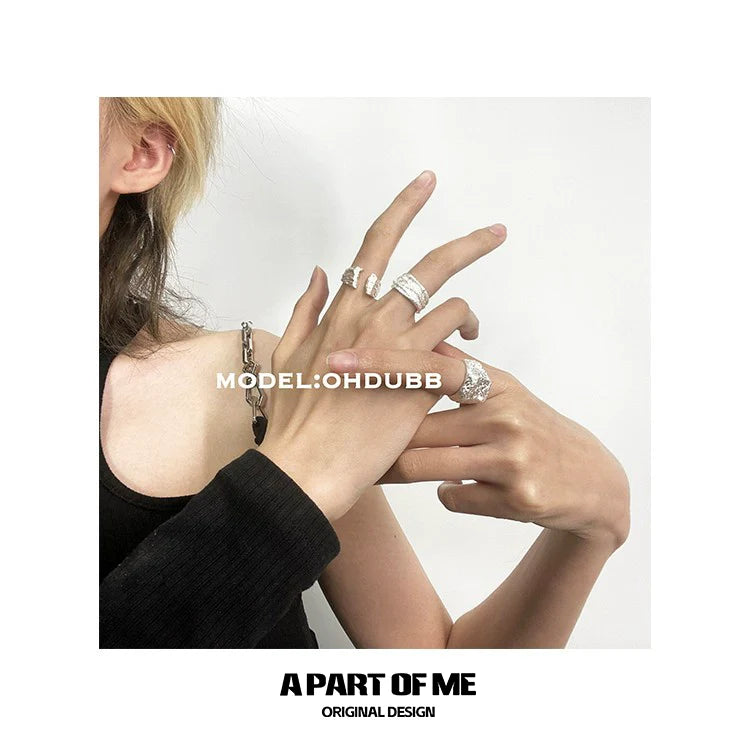 Stylish silver foil textured ring showcased with other rings on model's fingers for modern jewelry lovers