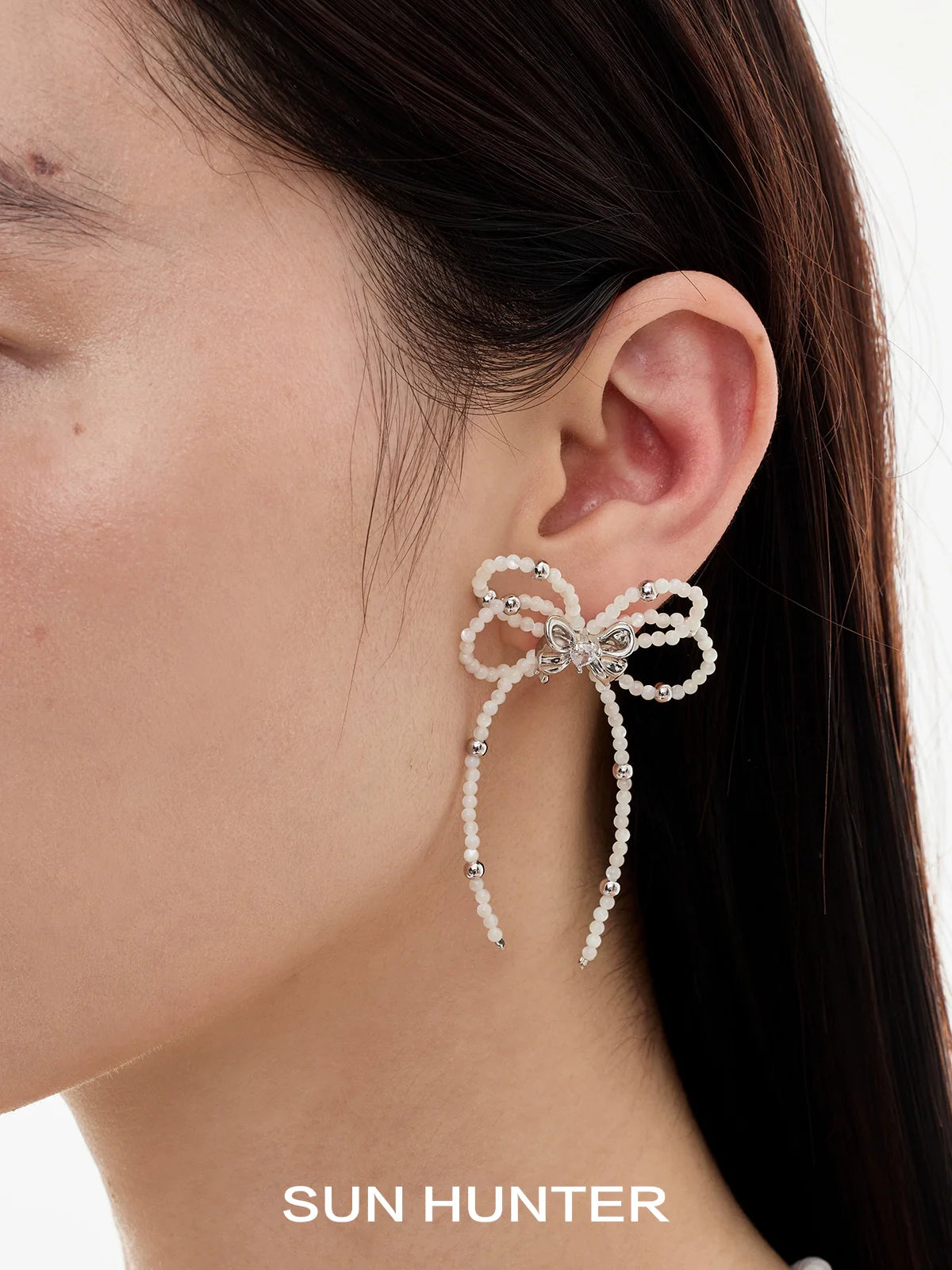 SUN HUNTER pearl bow ribbon earrings designed with elegant pearl detailing and sparkling accents