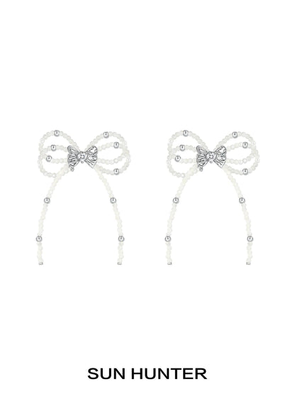 Elegant SUN HUNTER pearl bow ribbon earrings featuring sparkling accents for a stylish look