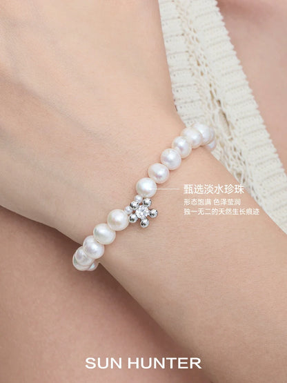 Elegant SUN HUNTER pearl bracelet for women featuring natural pearls and a sparkling flower design