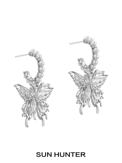 Elegant pearl butterfly earrings by SUN HUNTER featuring intricate metal design with pearl accents