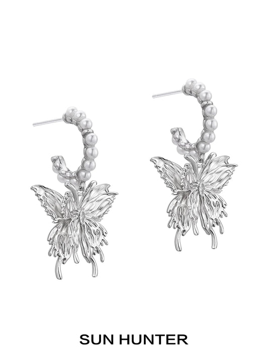 Elegant pearl butterfly earrings by SUN HUNTER featuring intricate metal design with pearl accents