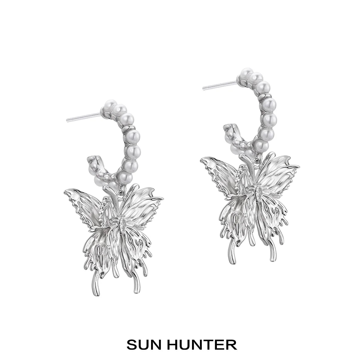Elegant SUN HUNTER pearl butterfly earrings with intricate design and luminous pearls