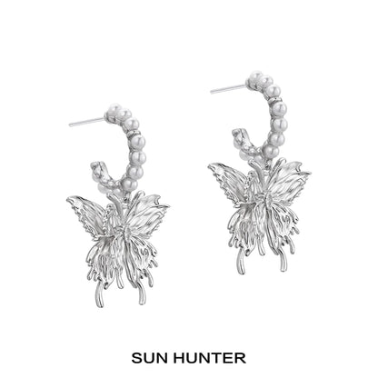 Elegant SUN HUNTER pearl butterfly earrings with intricate design and luminous pearls