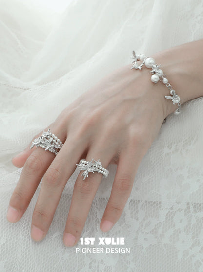 Elegant pearl butterfly ring showcased on a hand with matching pearl bracelet for a delicate look