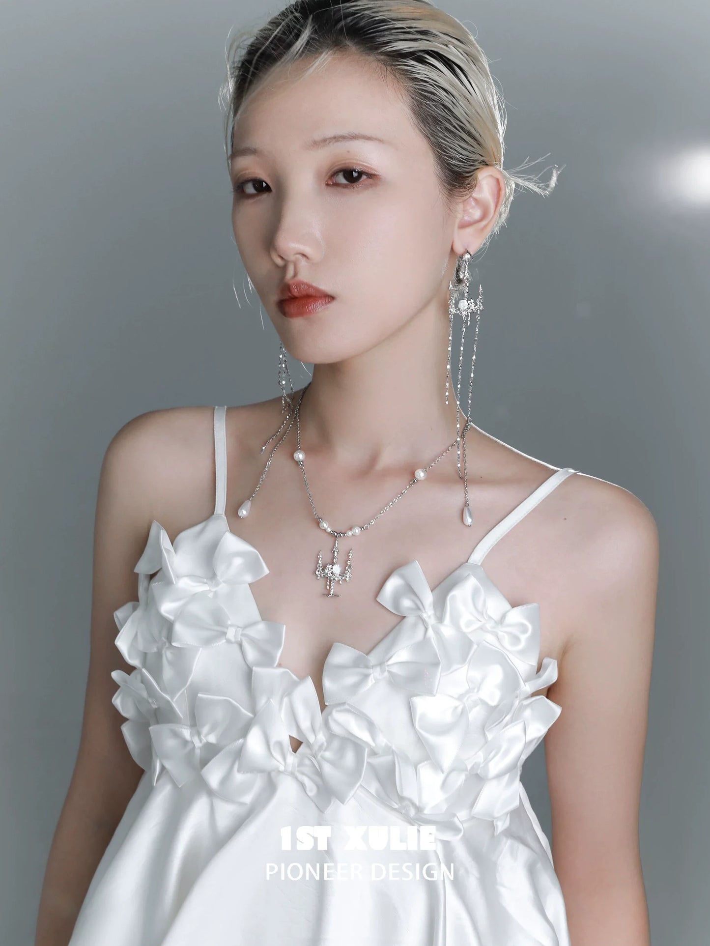 Elegant model wearing a pearl clavicle necklace paired with a white ruffled dress