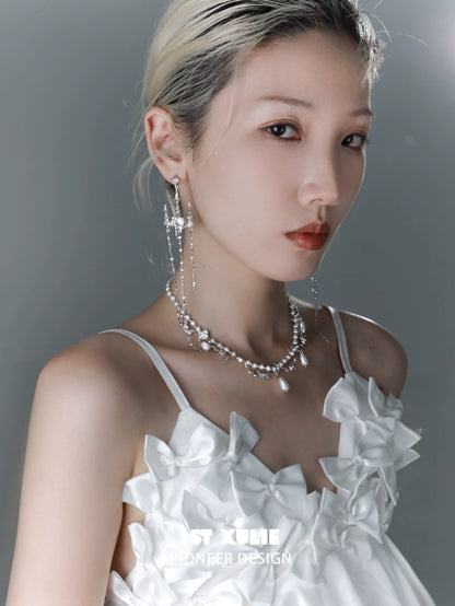 Elegant woman wearing a pearl clavicle necklace paired with a stylish white dress