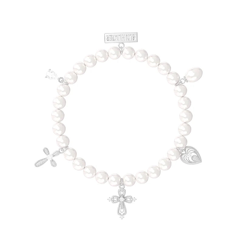 Elegant pearl cross bracelet featuring silver charms for a stylish accessory look