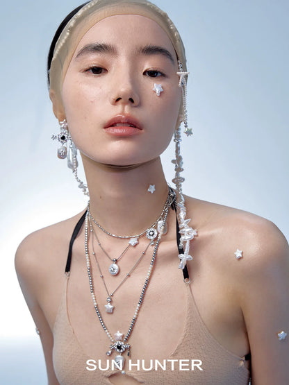 Fashionable model wearing SUN HUNTER pearl riddle rings along with layered necklaces and accessories