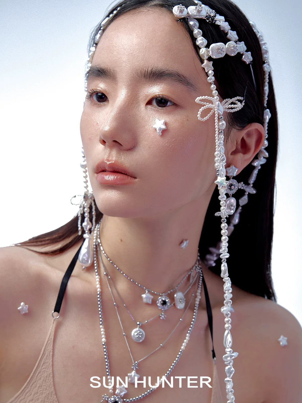 Model wearing pearl star bracelet along with layered necklaces for a stylish look