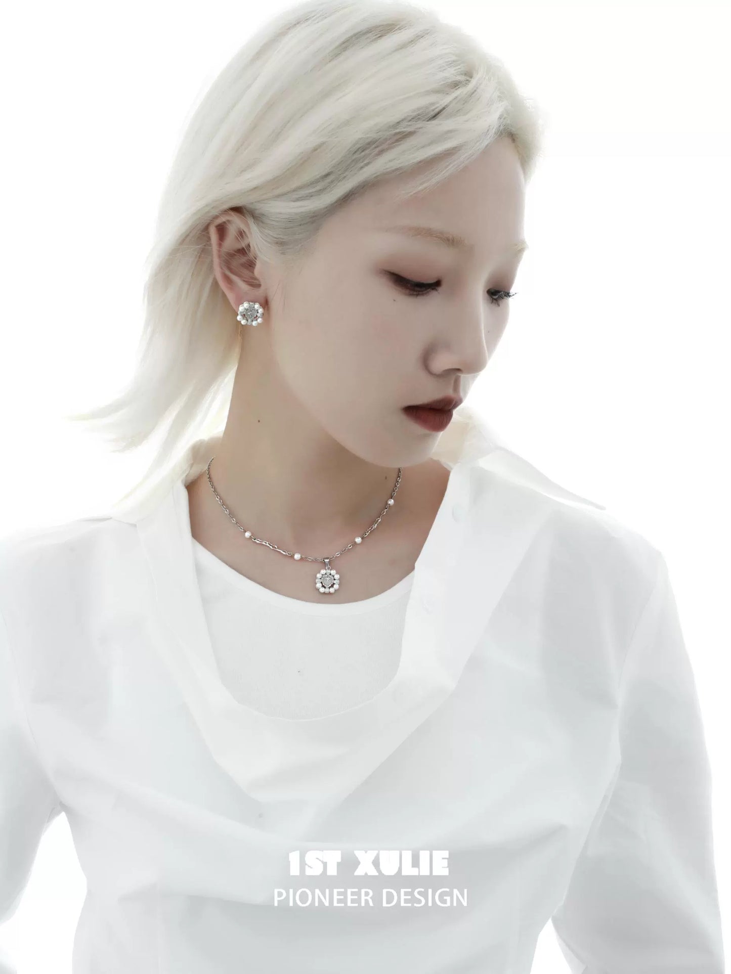 Elegant model wearing a pearl statement necklace paired with a white blouse for a chic look