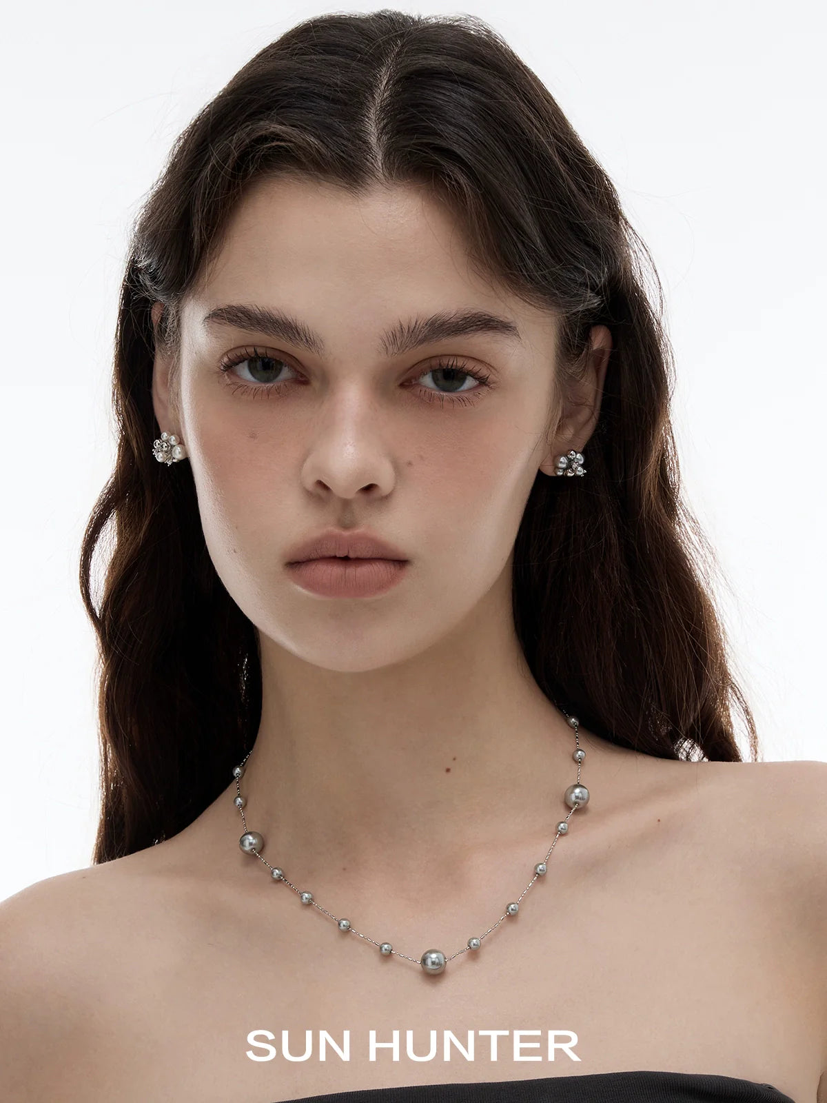 SUN HUNTER pearl zircon statement earrings featured on a model with a sleek hairstyle