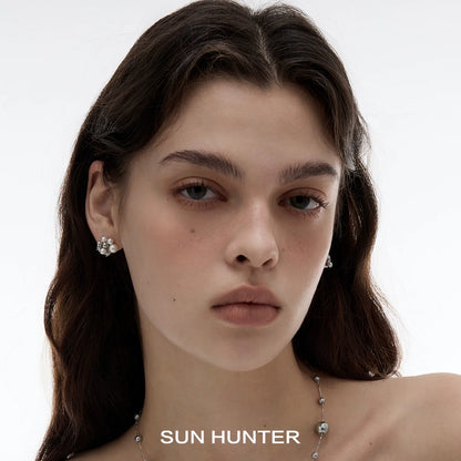 Elegant SUN HUNTER pearl zircon statement earrings showcased on a model's ear