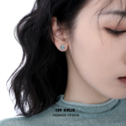 Aqua gemstone stud earrings showcased on a model, adding a touch of elegance to any outfit