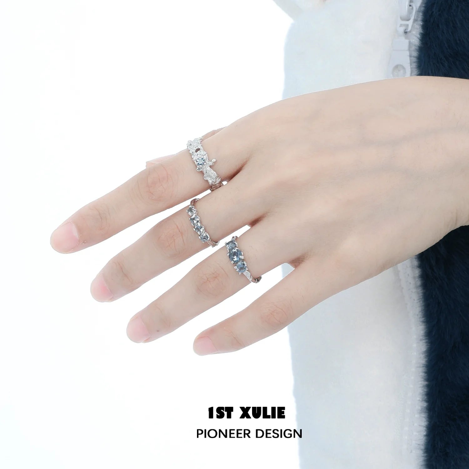 Three elegant rings worn on a hand, featuring the aurora glacier silver ring design