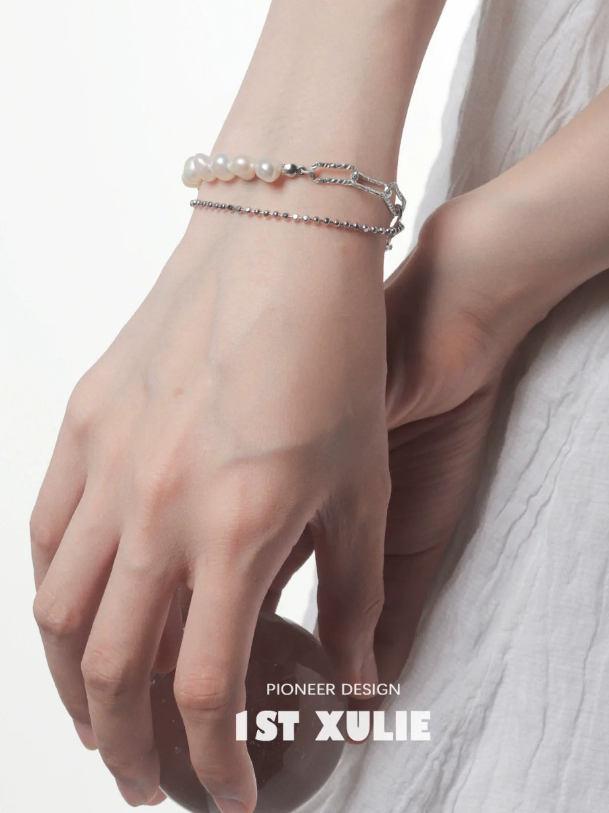 Baroque pearl silver bracelet featuring delicate pearls and elegant silver chains on a hand