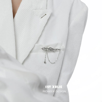 Elegant lava texture silver brooch attached to a white blazer for stylish detail