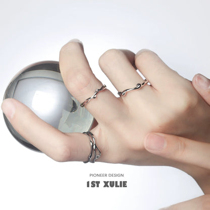 Minimalist silver line art ring showcased on hand holding a reflective sphere