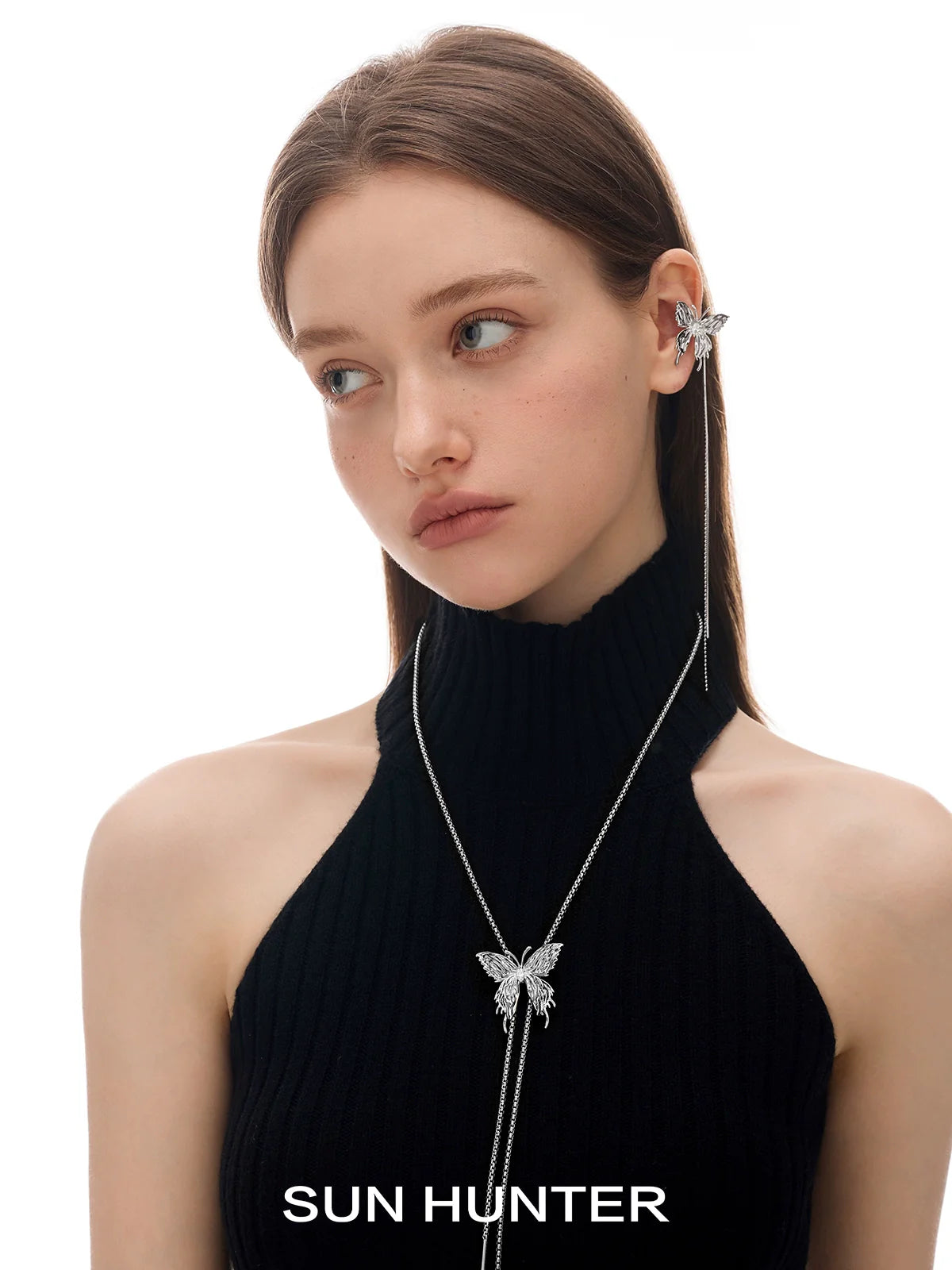 Model wearing SUN HUNTER punk butterfly ear cuffs with a stylish black top and sleek hairstyle