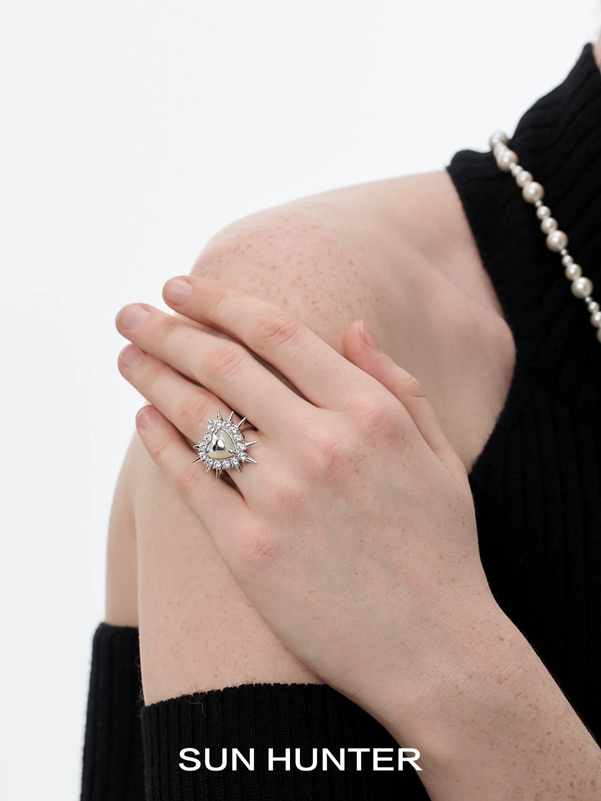 Silver SUN HUNTER punk heart rivet ring worn on a model's hand for a stylish look