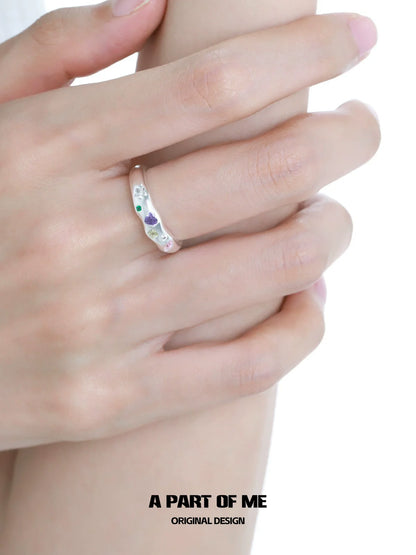 A PART OF ME rainbow zircon love ring displayed on a hand with multiple colors and heart designs