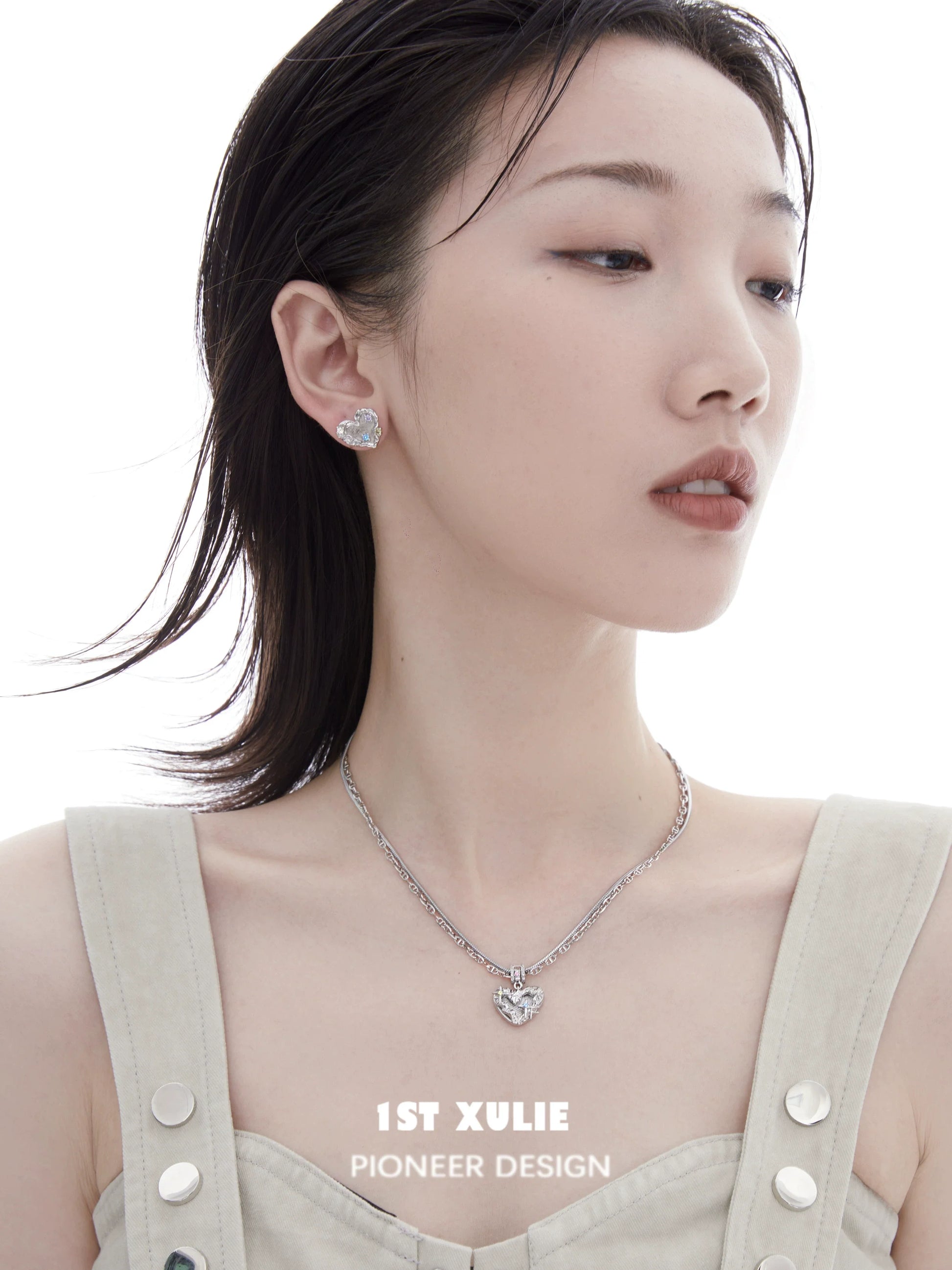Model wearing a removable clavicle chain necklace with a heart pendant and matching earrings