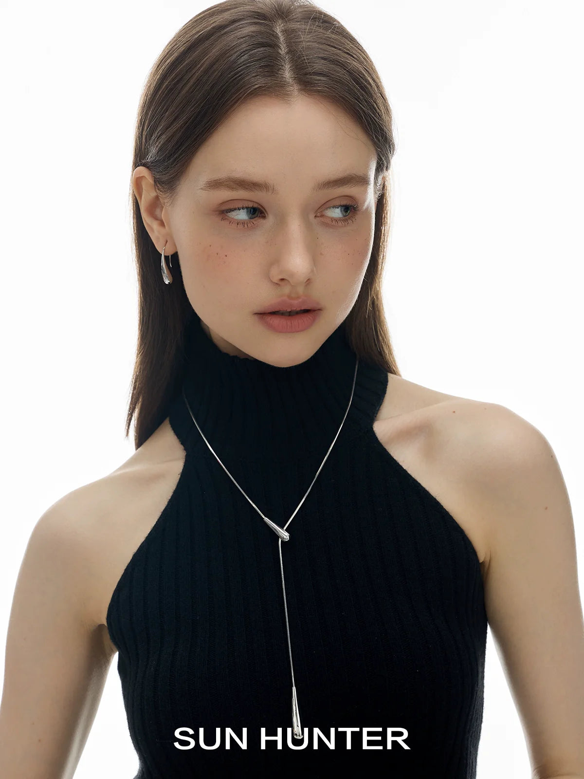 Model wearing retro metal water drop earrings from SUN HUNTER with a stylish black top