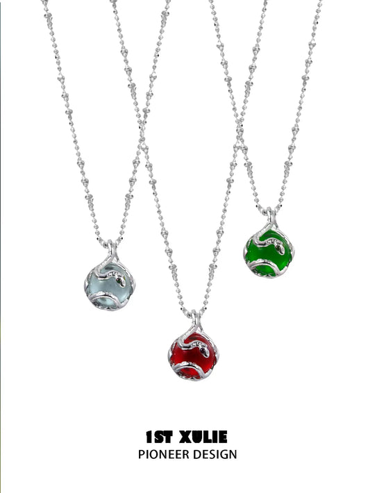 Three serpent silver necklaces with colorful pendants in blue, red, and green from 1STXULIE