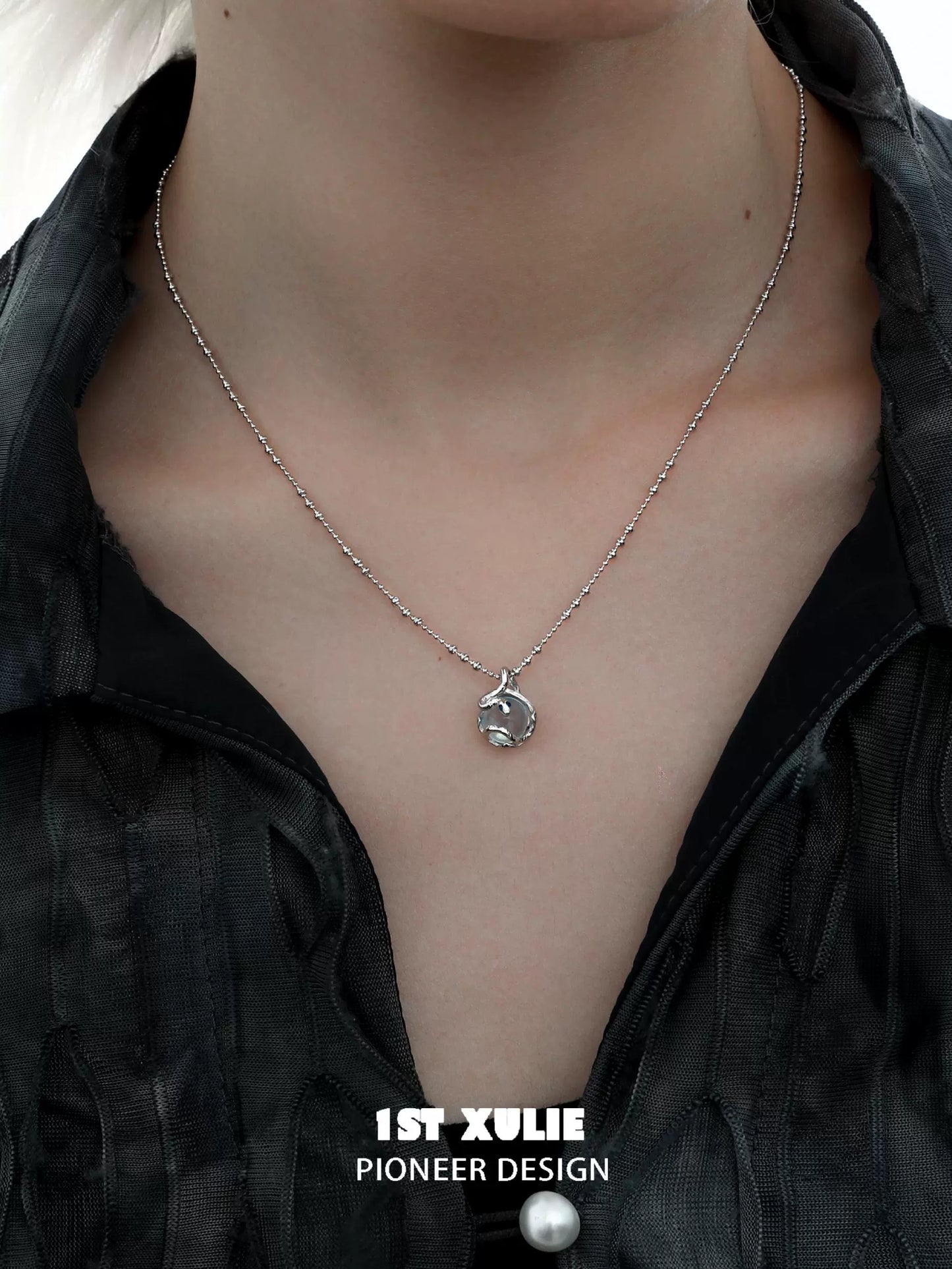 Stylish serpent silver necklace on model with a modern black outfit for a trendy look